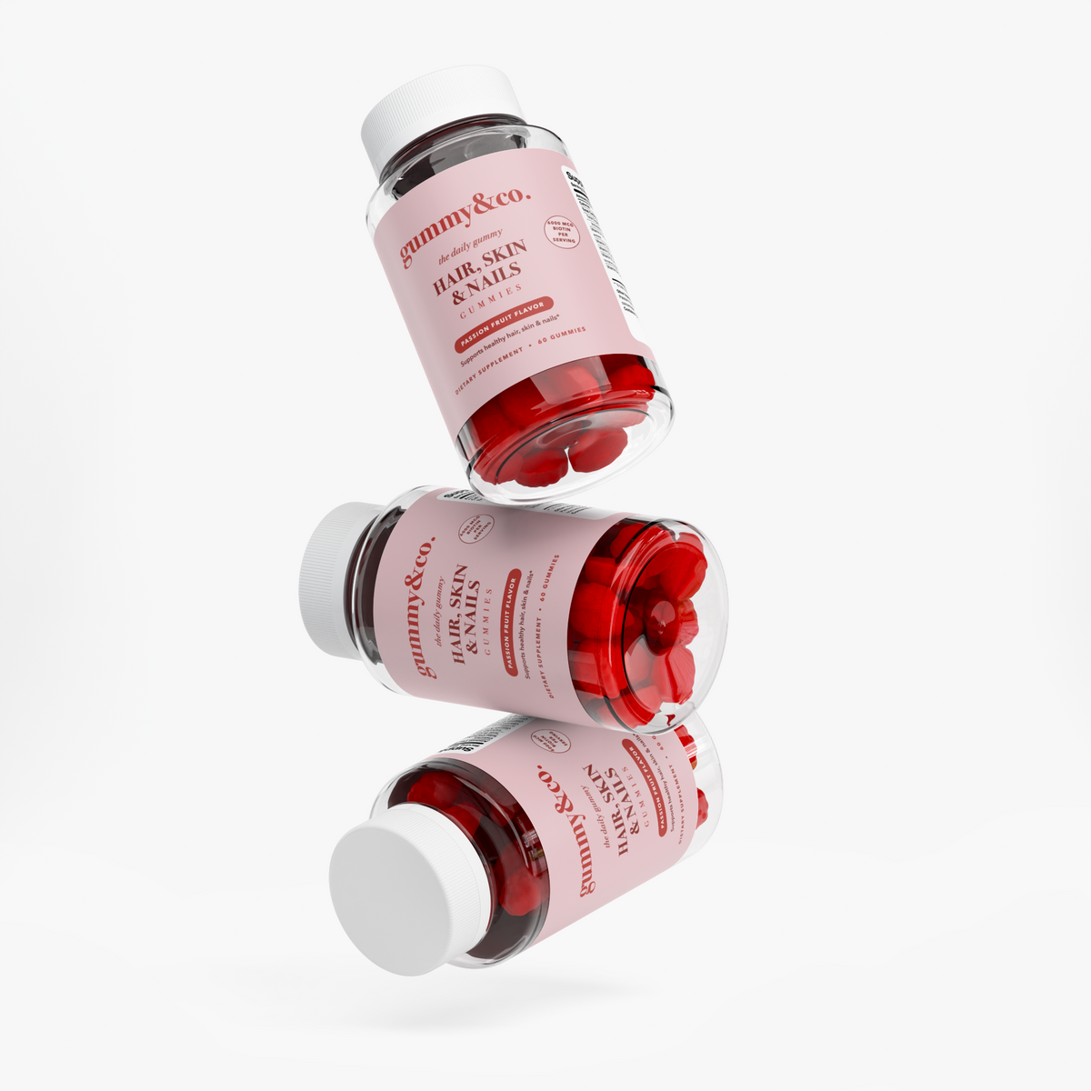 Three stacked bottles of Gummy & Co. Hair, Skin & Nails Gummies — the 90-day supply
